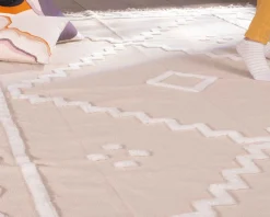 Discount Tapis beige tissé main et motifs brodés blancs 